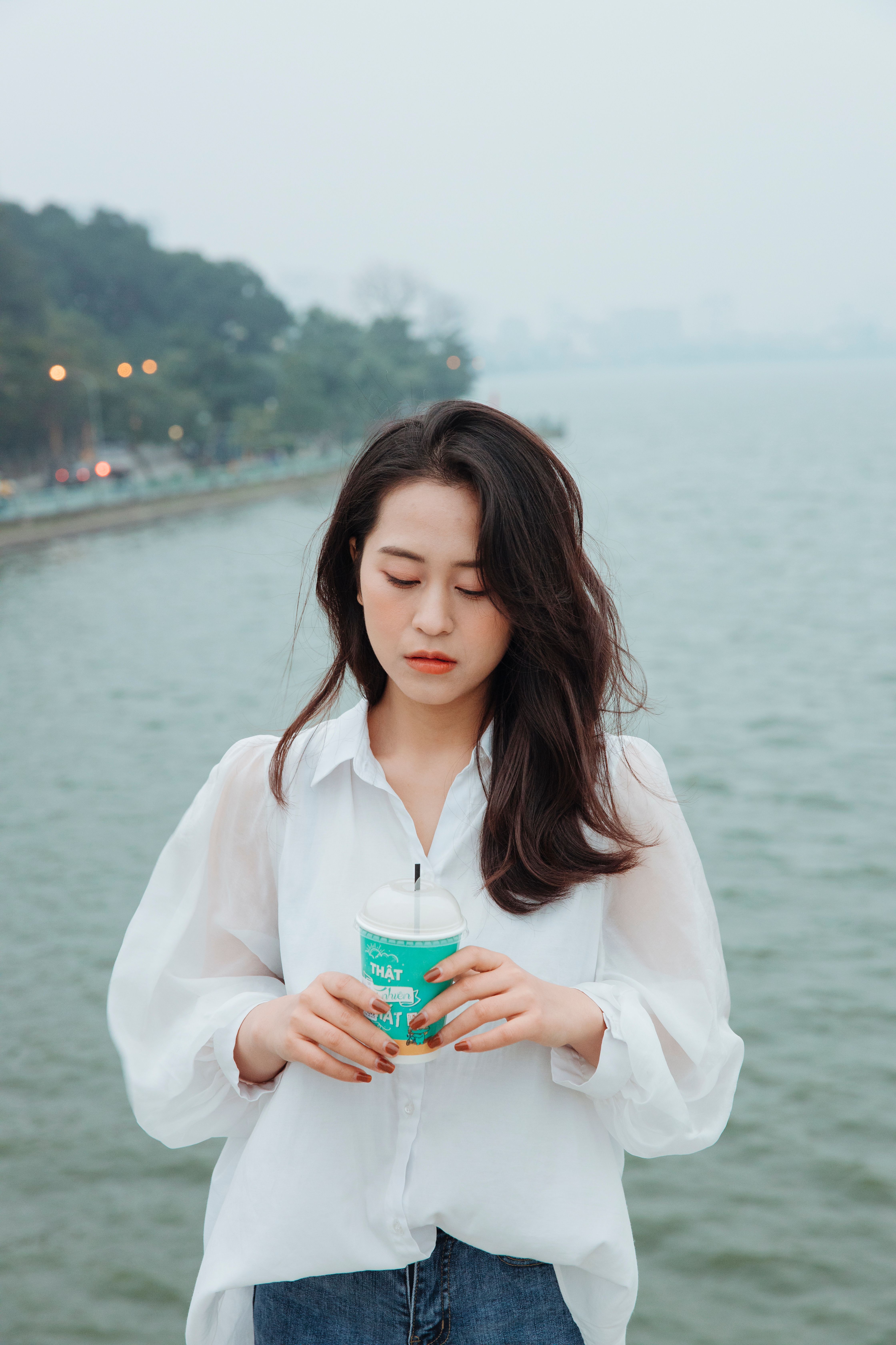 Woman in White Blouse Holding a Cup · Free Stock Photo