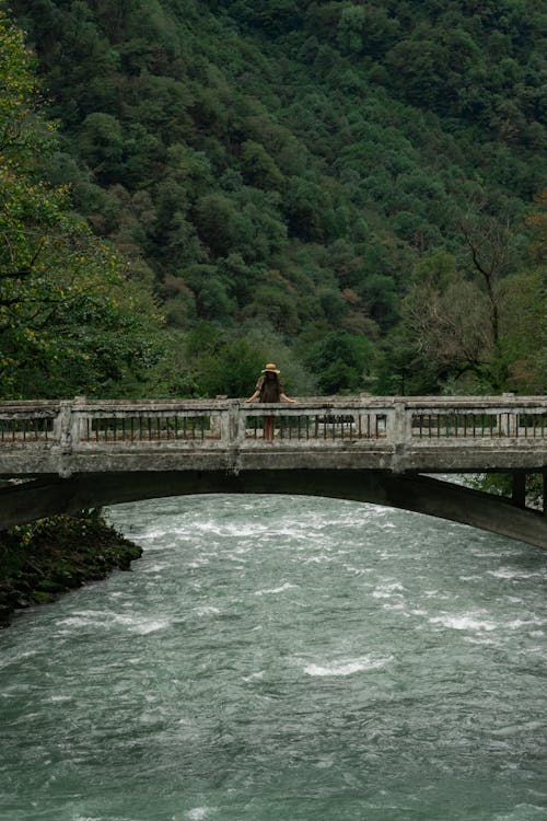 Woman Standing on Bridge Over Water 