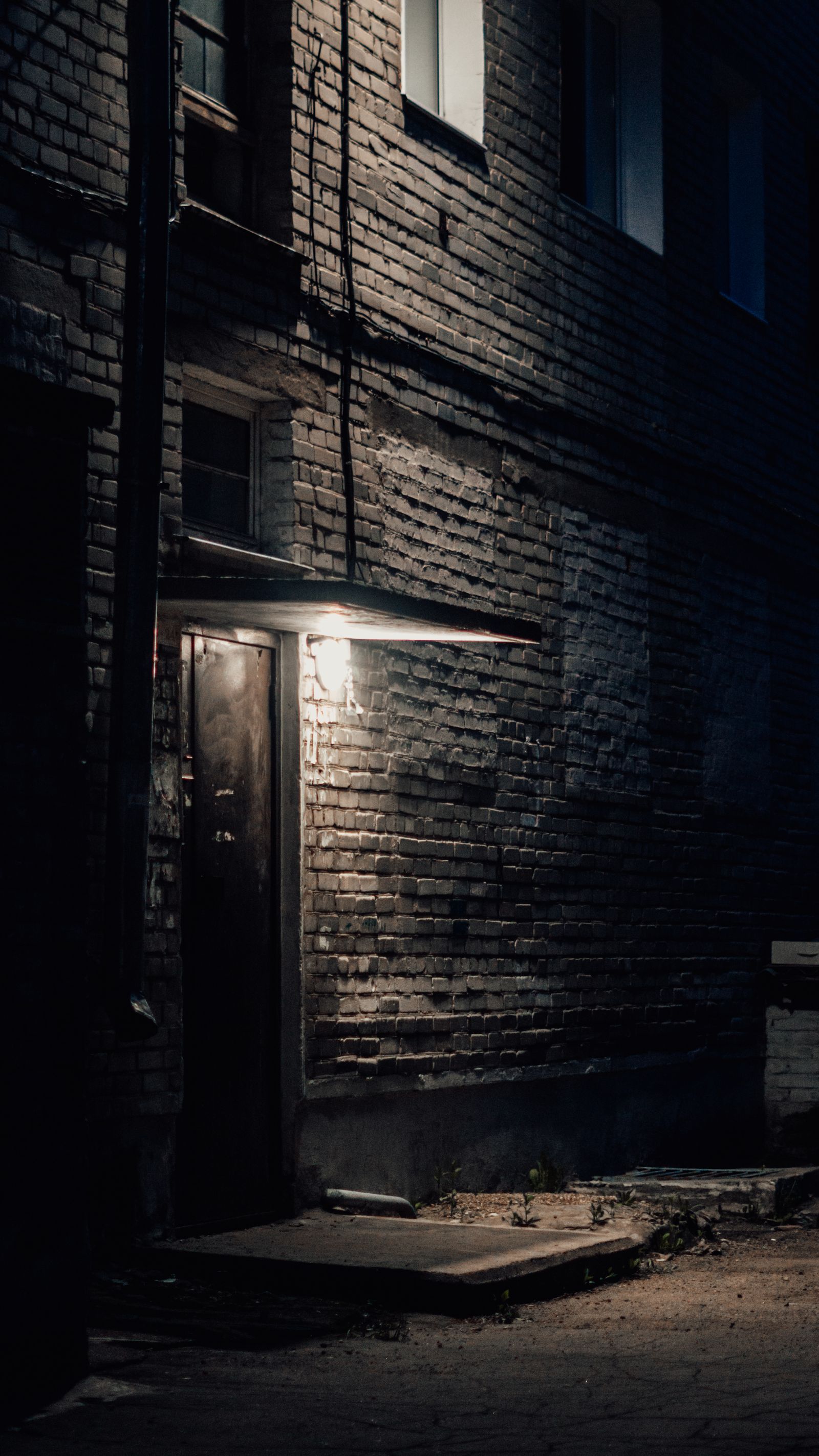 Dimly lit doorway of a brick building at night.