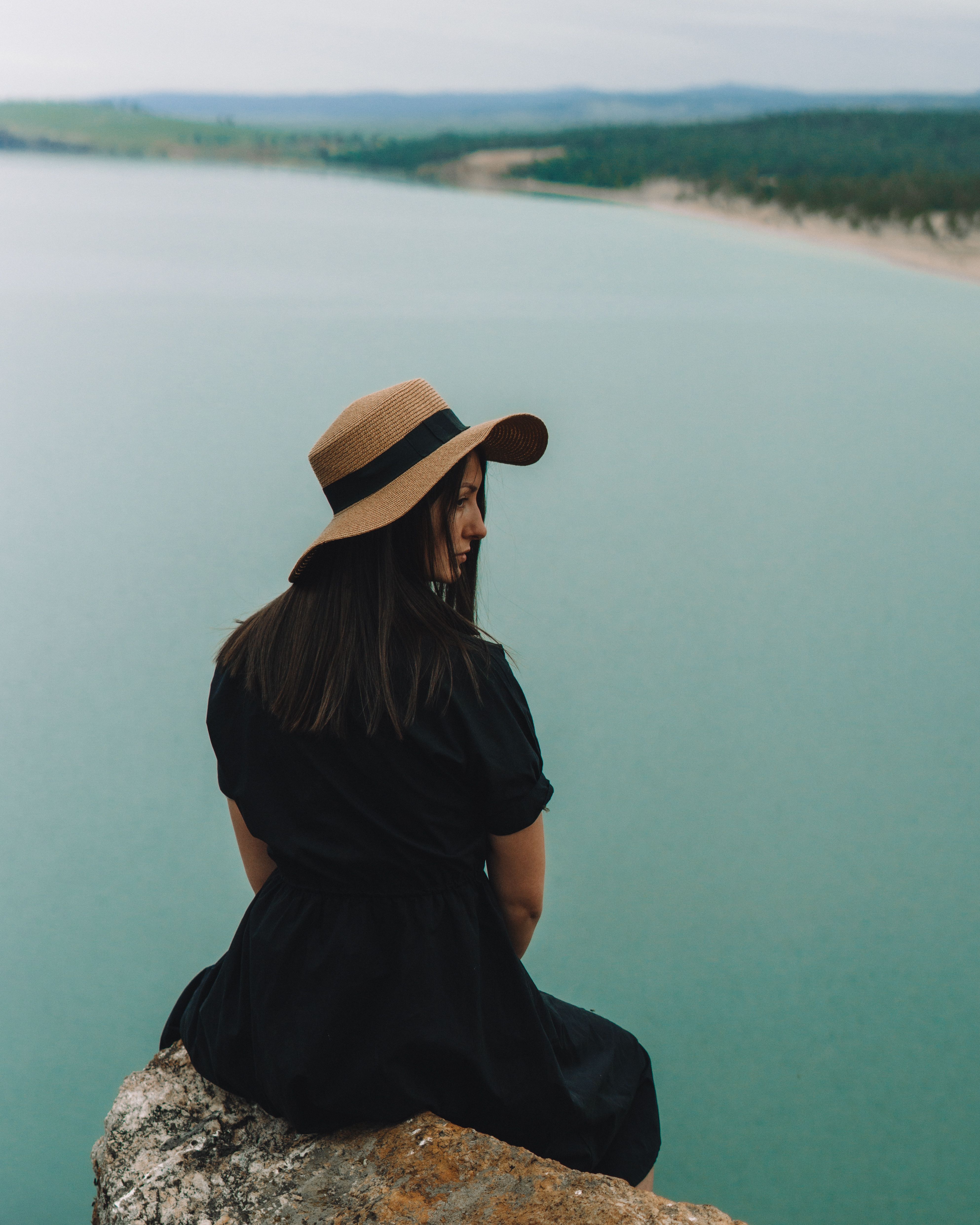Woman in Black Dress Sitting on Rock Cliff · Free Stock Photo