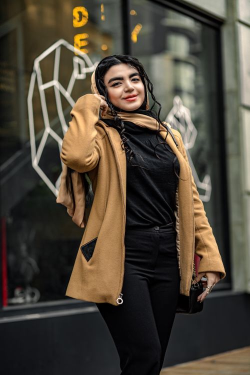 Free A fashionable woman smiling confidently on a street in Tehran, Iran. Stock Photo