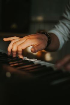 A close-up view of a man's hands skillfully playing the piano keys indoors.