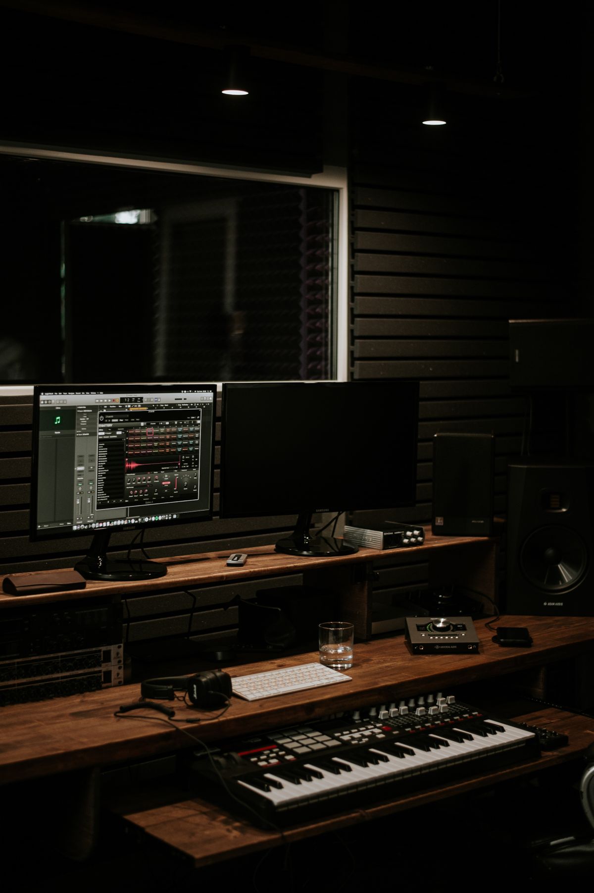 Dark modern music production studio setup with monitors and mixing gear