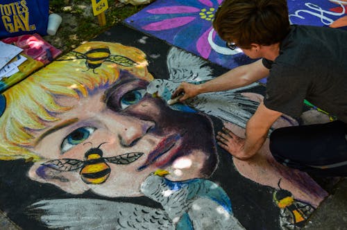 Man Painting Face of Human and Bird