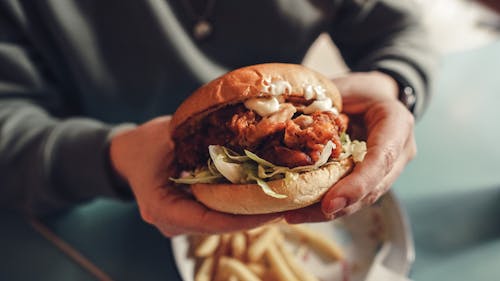 Person Holding a Beef Burger 