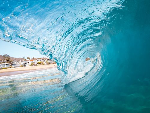 Free Captivating view from inside a curling ocean wave at a California beach. Stock Photo