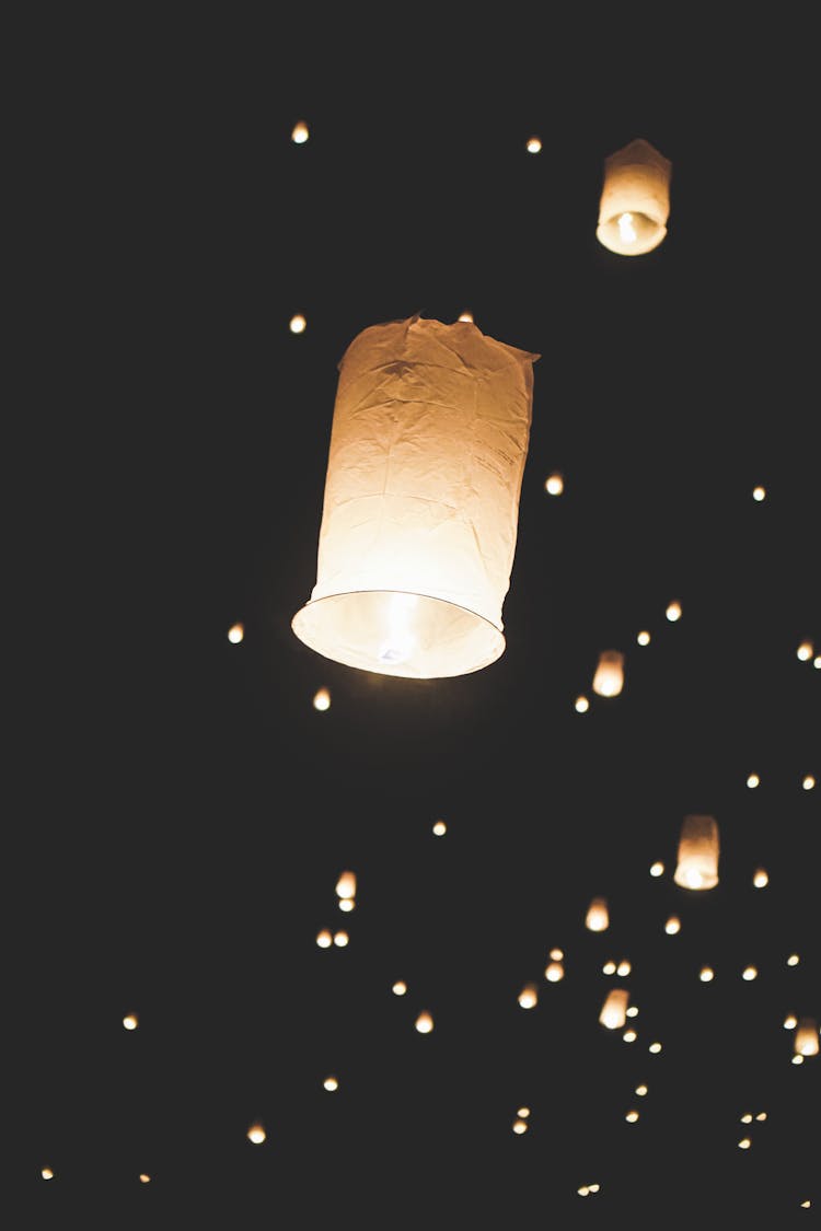 Flying Paper Lanterns In Black Night Sky