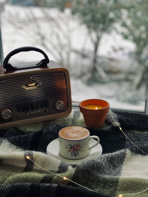 Free Brown Radio Beside White Ceramic Mug on Gray Textile Stock Photo