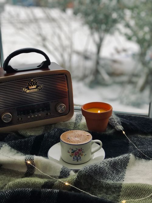 Free Warm and inviting winter setting featuring a vintage radio, candle, and coffee. Perfect for cozy afternoons. Stock Photo