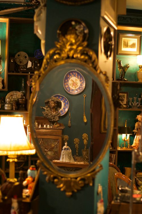 Free Elegant mirror reflection showcasing vintage decor in an antique shop setting. Stock Photo
