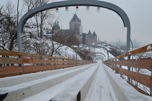A snow-covered toboggan slide with a historic building in Quebec City in winter.