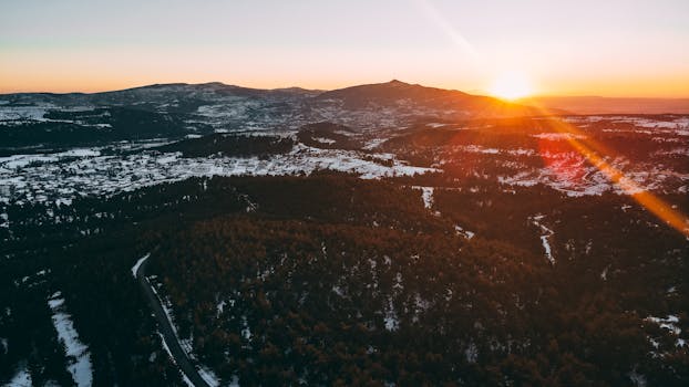 Stunning aerial view of Karaağaç, Turkey at sunrise during winter, showcasing snow-covered landscapes and forests.