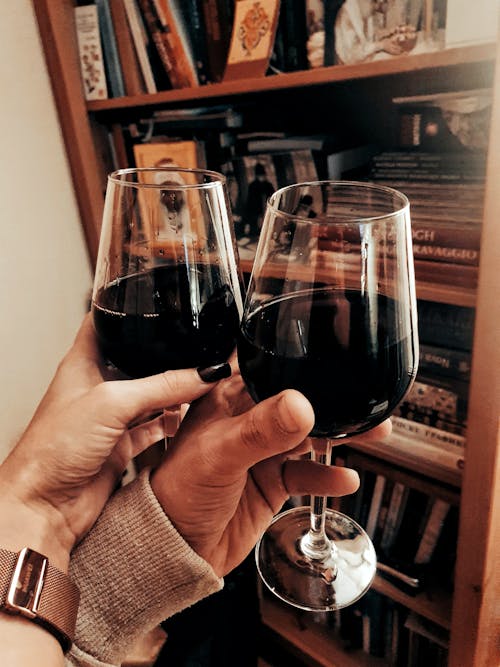 Close-Up Shot of Two People Holding Wine Glasses