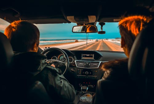 Men Driving in Car on Road in Countryside