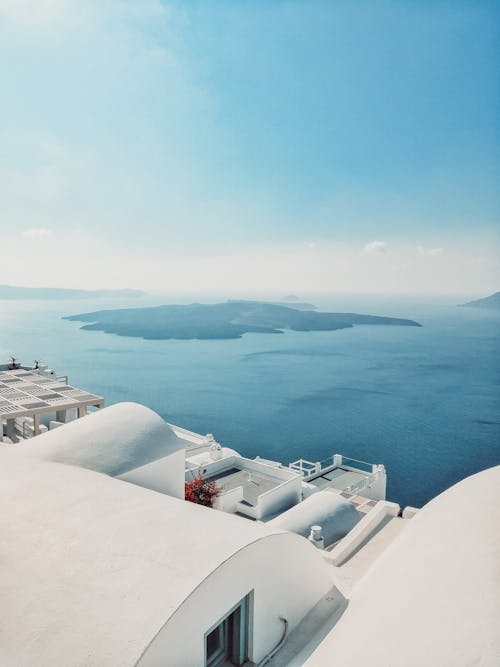 Silhouette of an Island in the Middle of Body of Water under Blue Sky