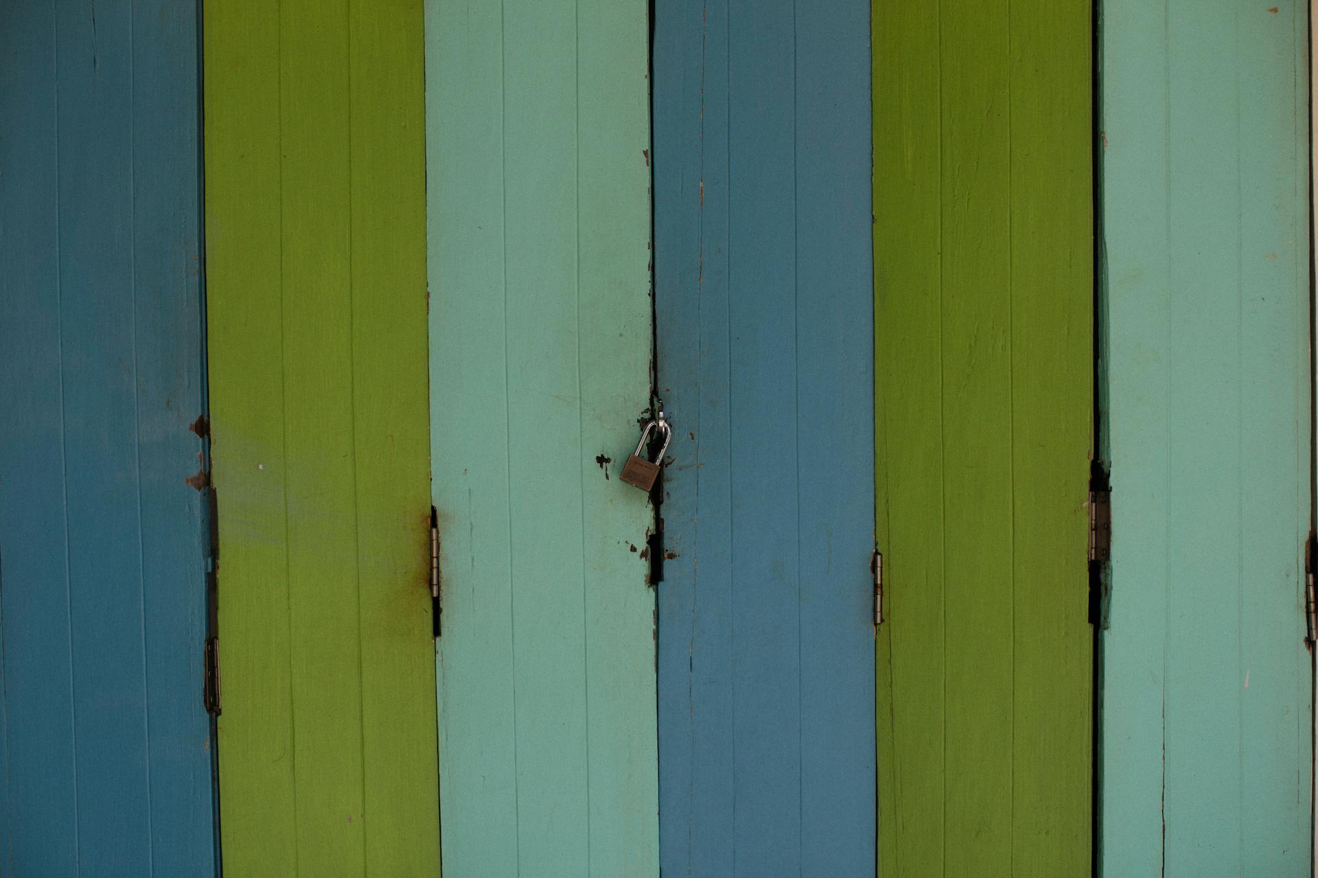 Vibrant wooden door panels with a secure padlock, emphasizing security and design.