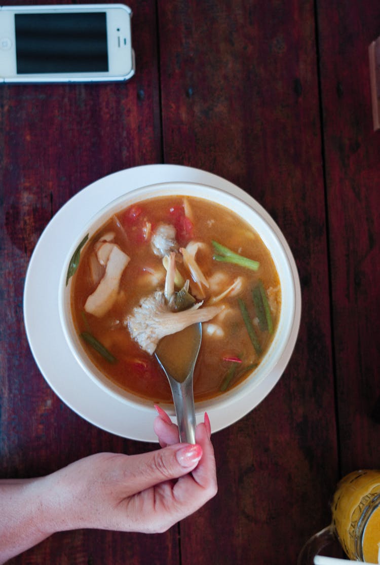 Woman Hand Holding Spoon In Soup