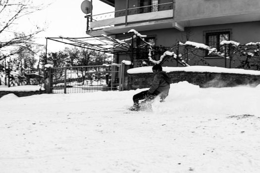 A teenager sledding on a snowy day, capturing winter fun and carefree childhood moments.