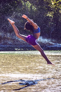 夏日里，一位女子优雅地跃过小河，捕捉着运动与快乐