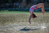 一个穿着五颜六色泳衣的年轻女孩正在海滩上戏水