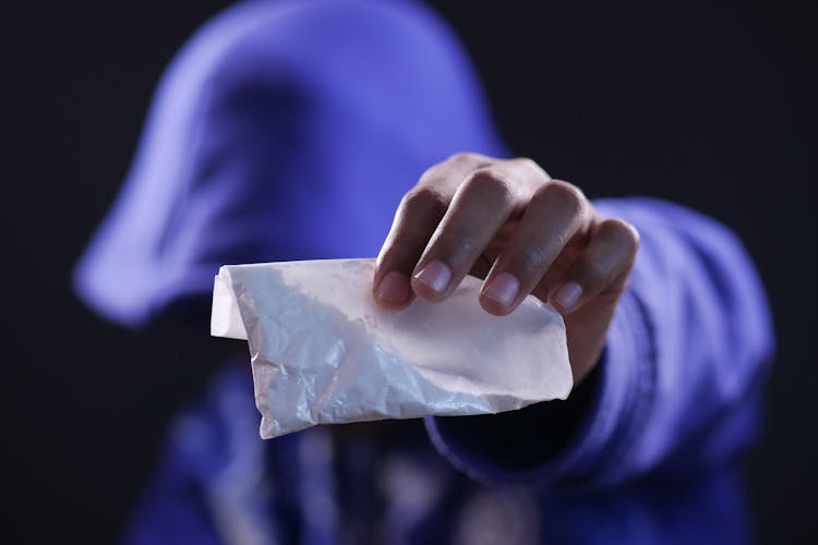 Close-Up Shot Of A Person Holding A White Sachet