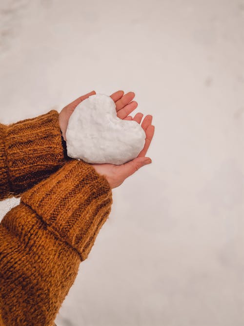 Heart-Shaped Snow on a Person's Hands