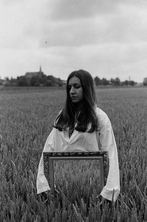 Free Grayscale Photo of a Woman Holding Mirror in the Field Stock Photo