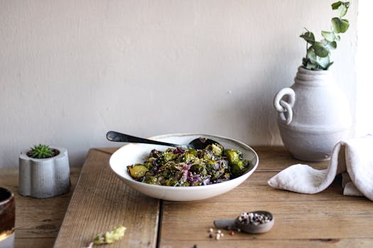 Healthy roasted Brussels sprouts with seeds in a ceramic bowl on a wooden table by window.