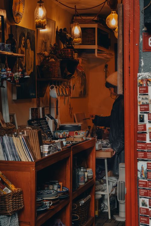 Free Warm ambiance of a small Istanbul bookstore with artwork and a shopper browsing. Stock Photo