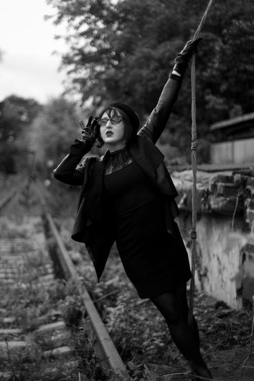 Grayscale Photo of a Woman Holding on a Rope