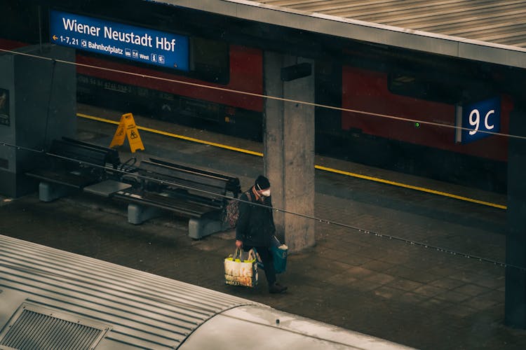 A Man Walking While Carrying Bags