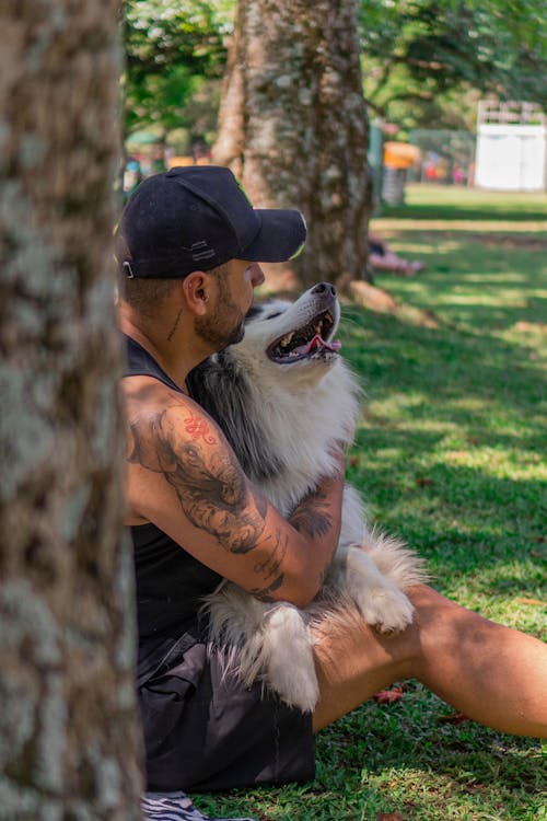 
A Tattooed Man Hugging His Dog