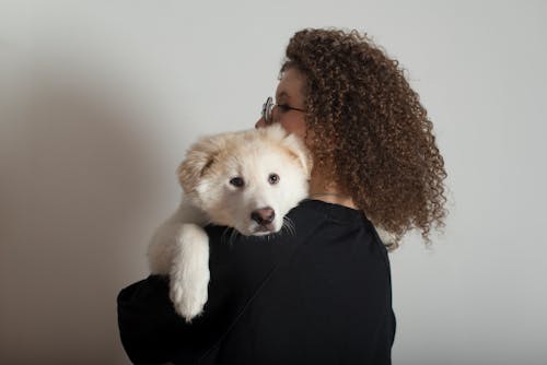Woman with Curly Hair Carrying a Dog