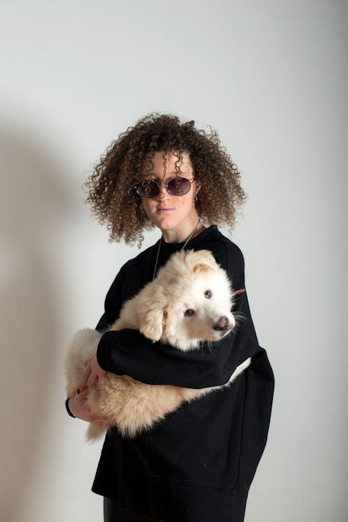 Woman with Curly Hair Carrying a Dog