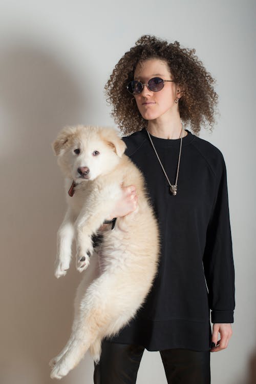 Woman in Black Long Sleeve Shirt Holding a Dog