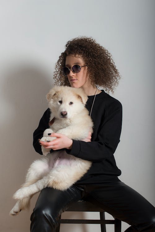 Woman Wearing Sunglasses Holding a Dog