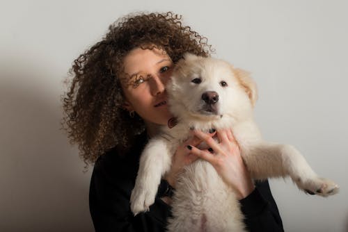 Photo of a Woman Carrying a Dog