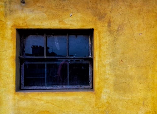 Closeup of Weathered Yellow Wall with a Window
