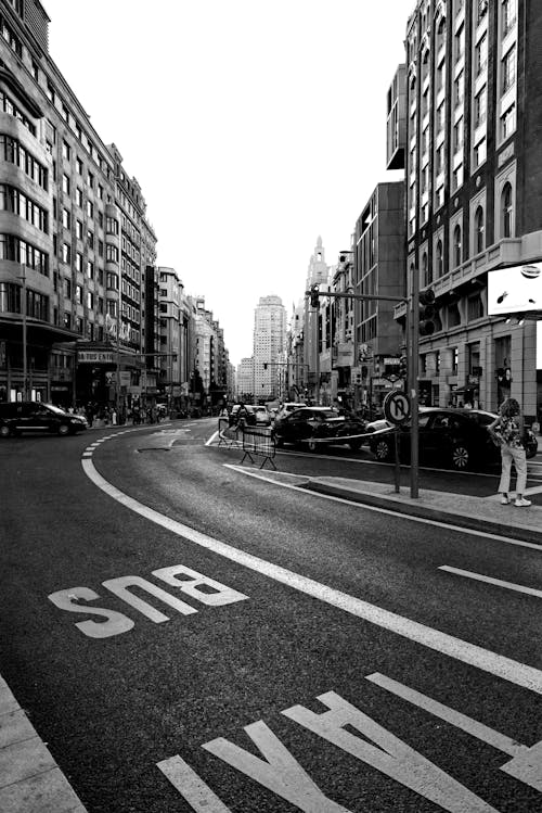 Black and White Photo of a City Street with Townhouses and Road Marking