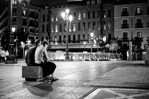 Man and Woman Sitting on Bench in Grayscale Photography
