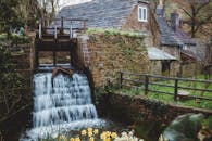 迷人的石磨，被郁郁葱葱的绿植和春天的花朵环绕的瀑布