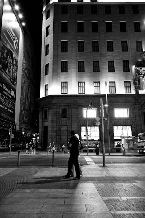 Grayscale Photo of Two People Walking on the Street