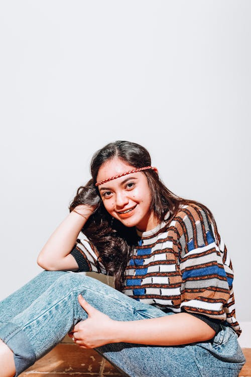 A Woman Sitting Wearing Denim Jeans