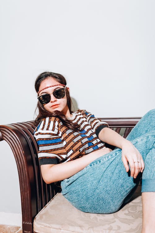 Woman in Blue Denim Jeans Wearing Black Sunglasses 