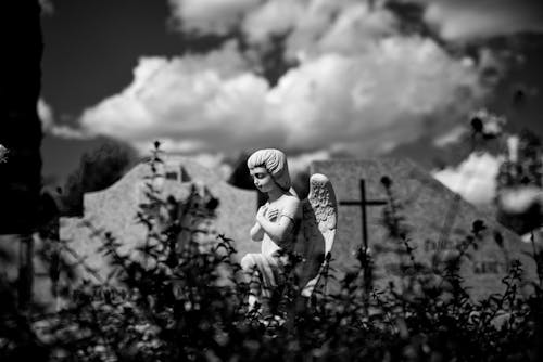 Grayscale Photo of a Small Stone Angel Statue