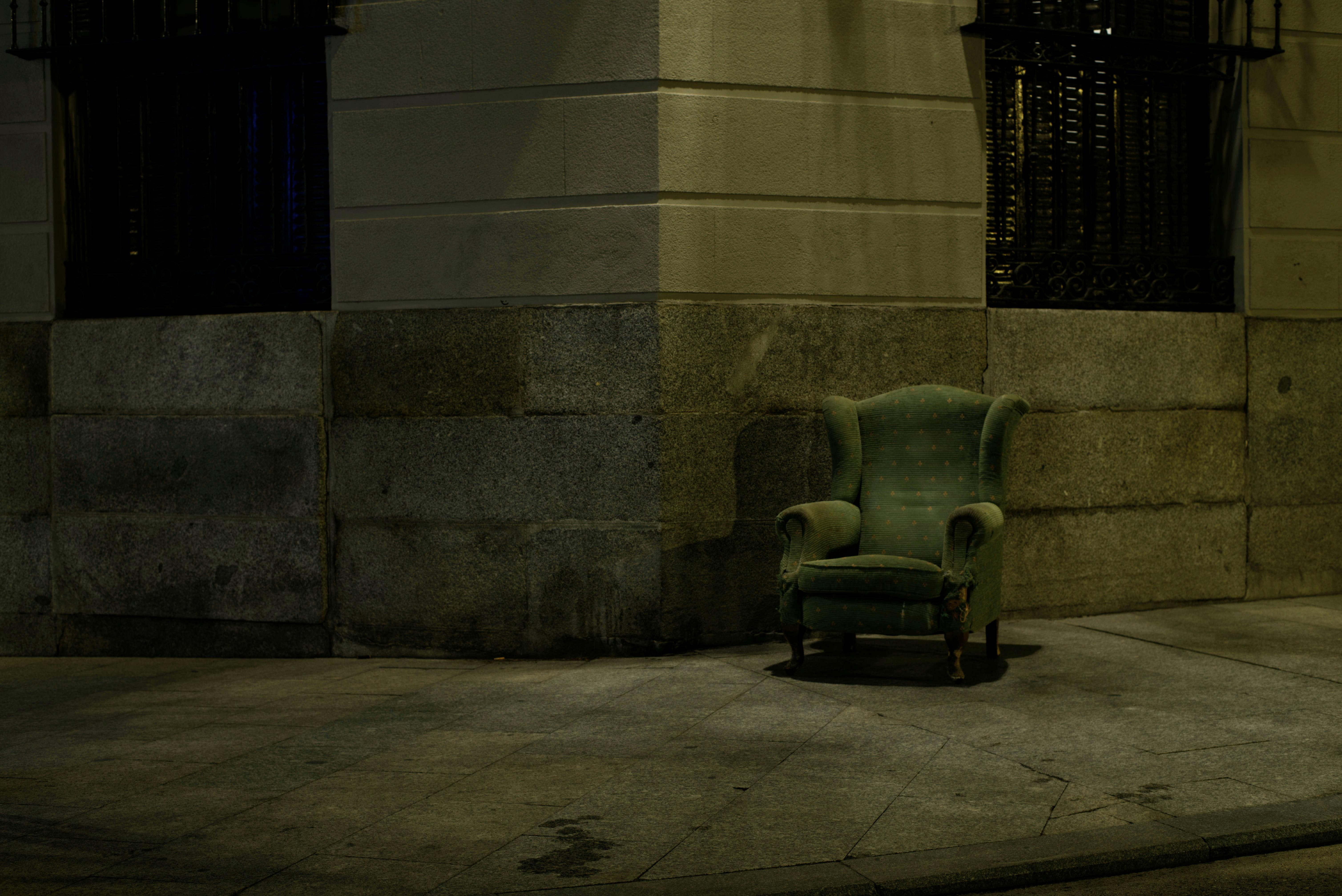 a gray couch near a concrete building