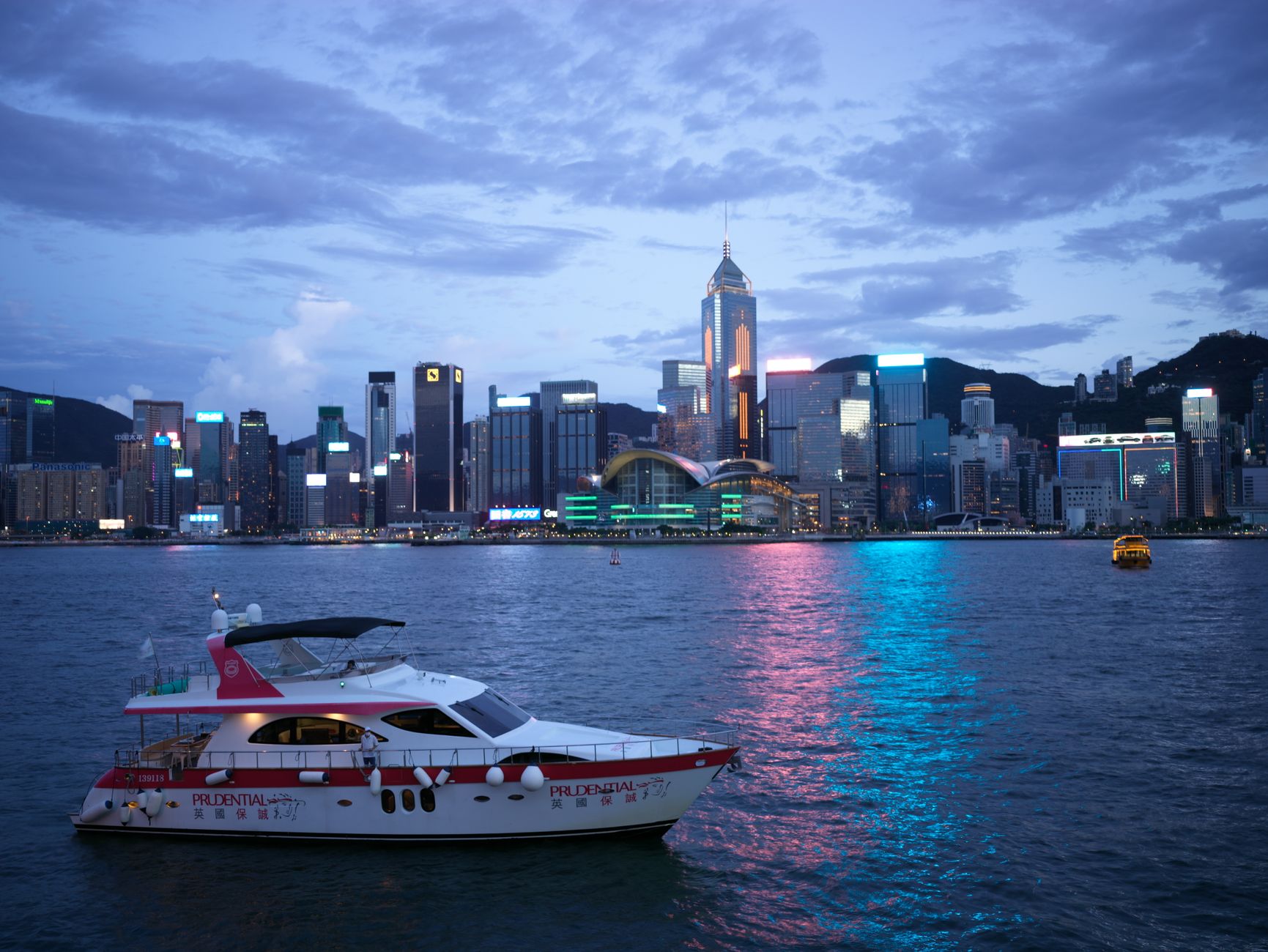 Hong Kong harbor at night with a glowing skyline reflected on the water.