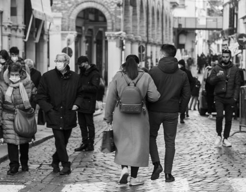 Free Black and white photo of a busy street with masked pedestrians walking. Stock Photo