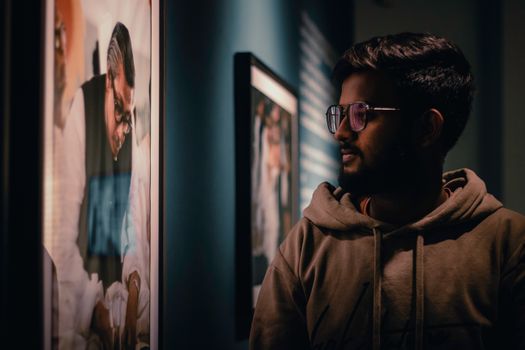 Man Looking at Framed Photography at an Exhibition