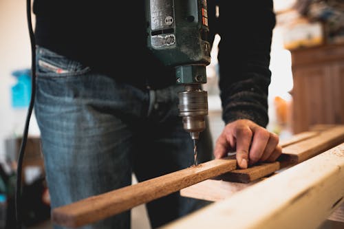 Man Met Houten Stok Tijdens Het Boren Van Een Gat